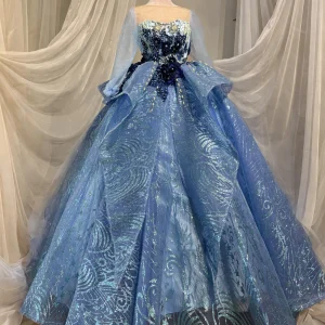 Dusty blue quinceanera dress with sheer cape sleeves, front view